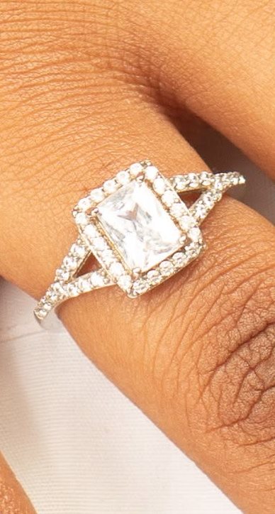 Emerald-cut halo ring with a split shank on a finger