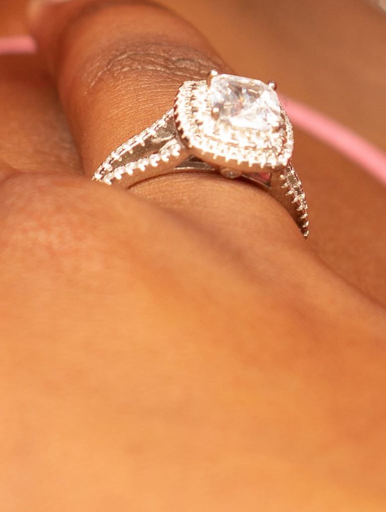 Cushion halo ring with a split shank on a finger