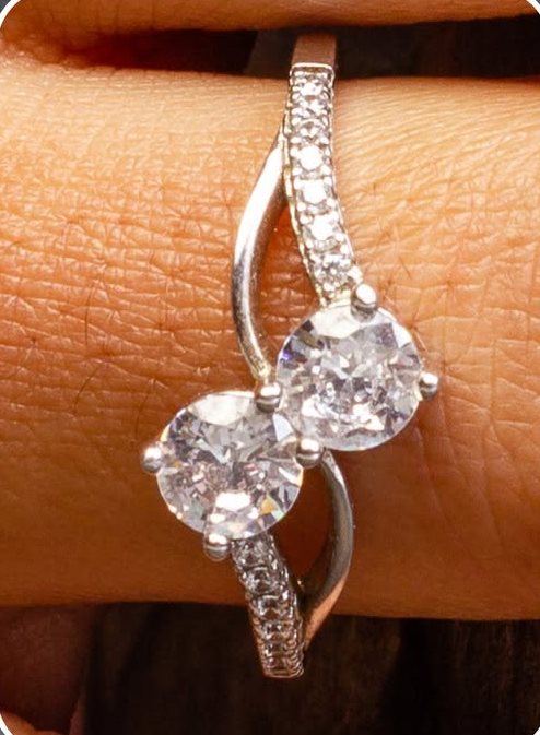 Two-stone twist ring with pavé detail on a finger